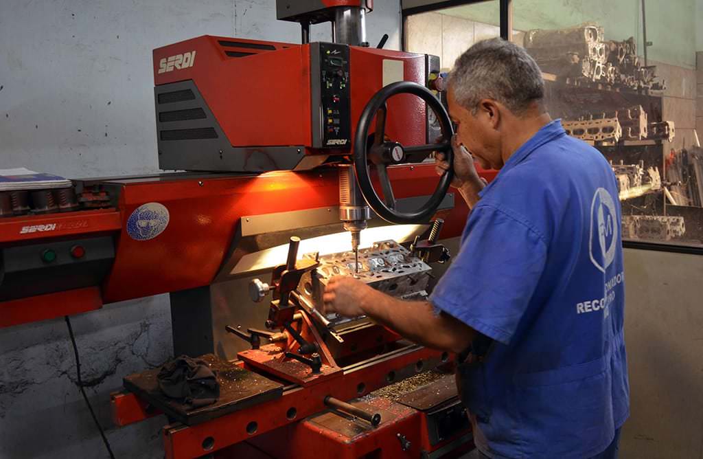 Profissional da Retífica Monteiro operando máquina de usinagem em um cabeçote